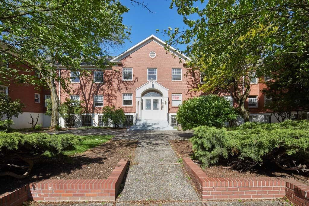 a large brick building with a white door at MILEPOST 5 Apartments, PORTLAND Oregon