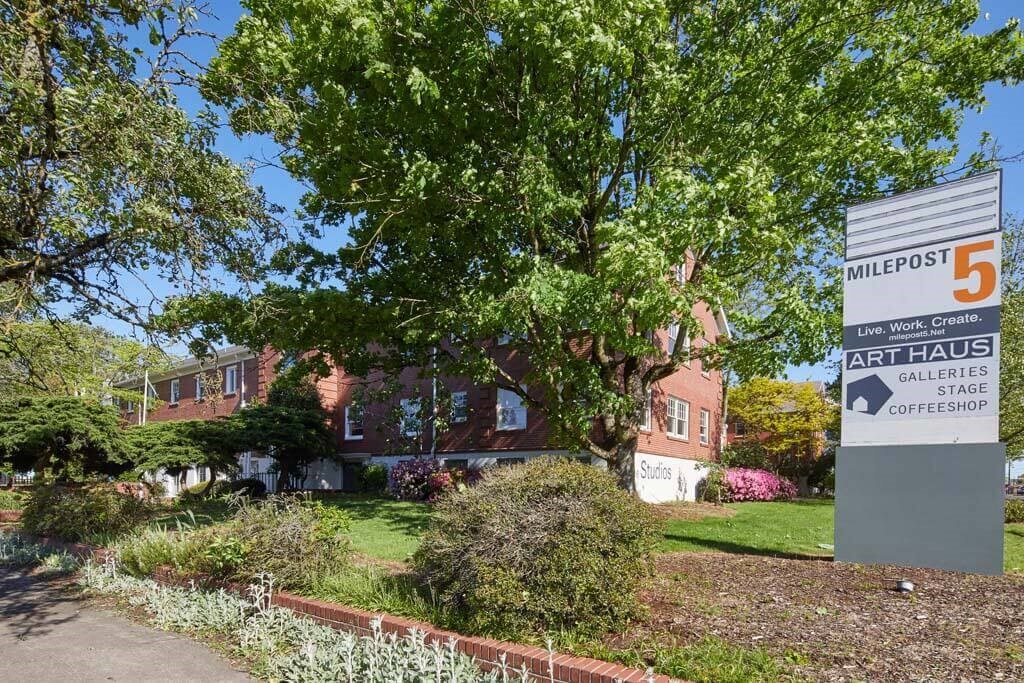 a building with a sign in front of it at MILEPOST 5 Apartments, PORTLAND, OR