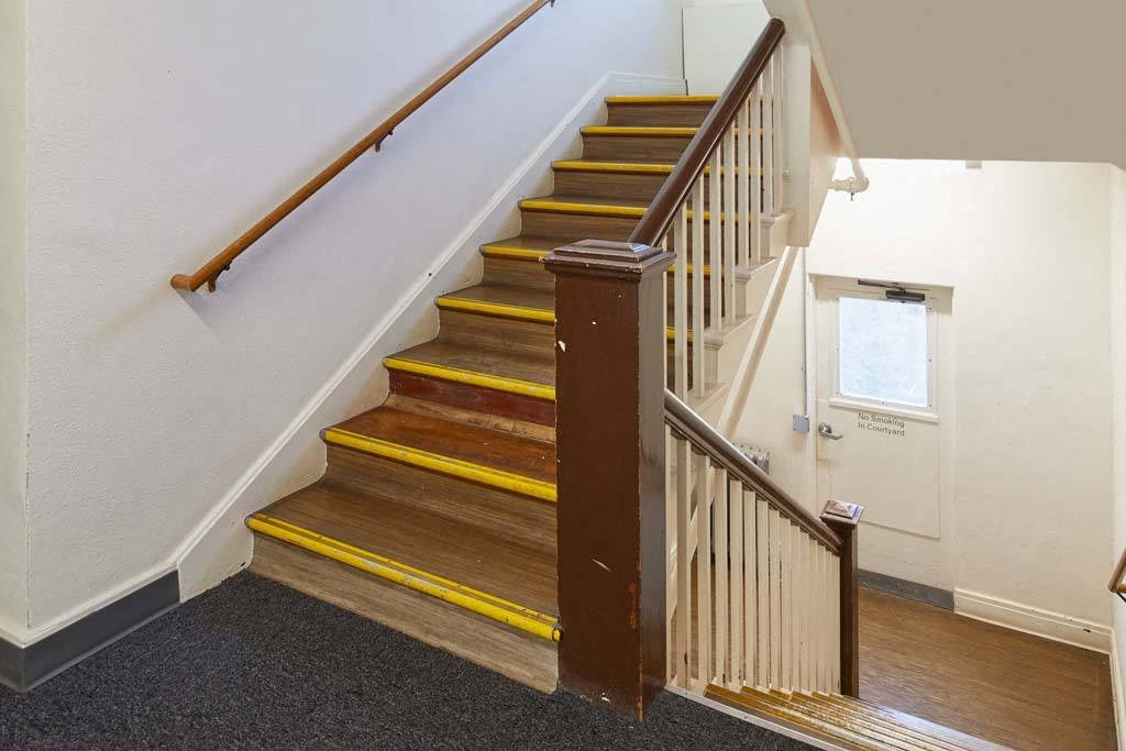 a staircase with wooden steps and a wooden railing at MILEPOST 5 Apartments, PORTLAND