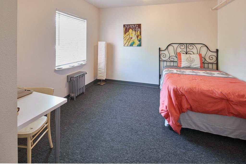 a bedroom with a bed and a desk at MILEPOST 5 Apartments, PORTLAND, 97213
