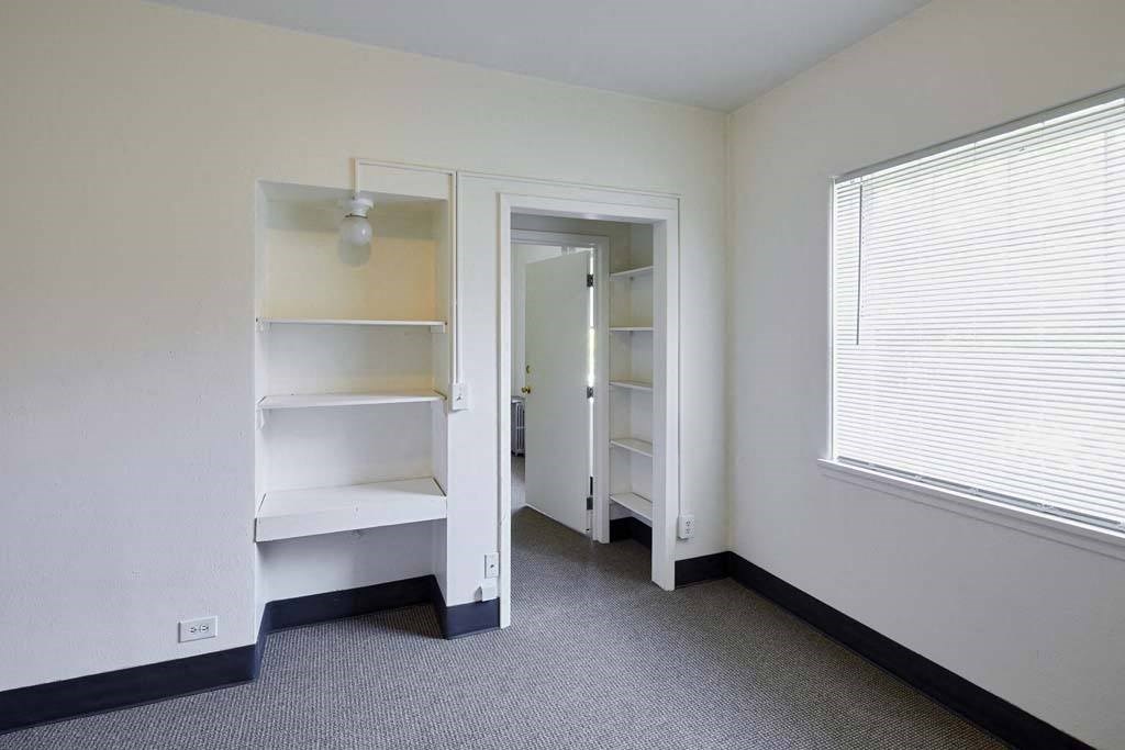 a bedroom with a book shelf and a window at MILEPOST 5 Apartments, PORTLAND Oregon