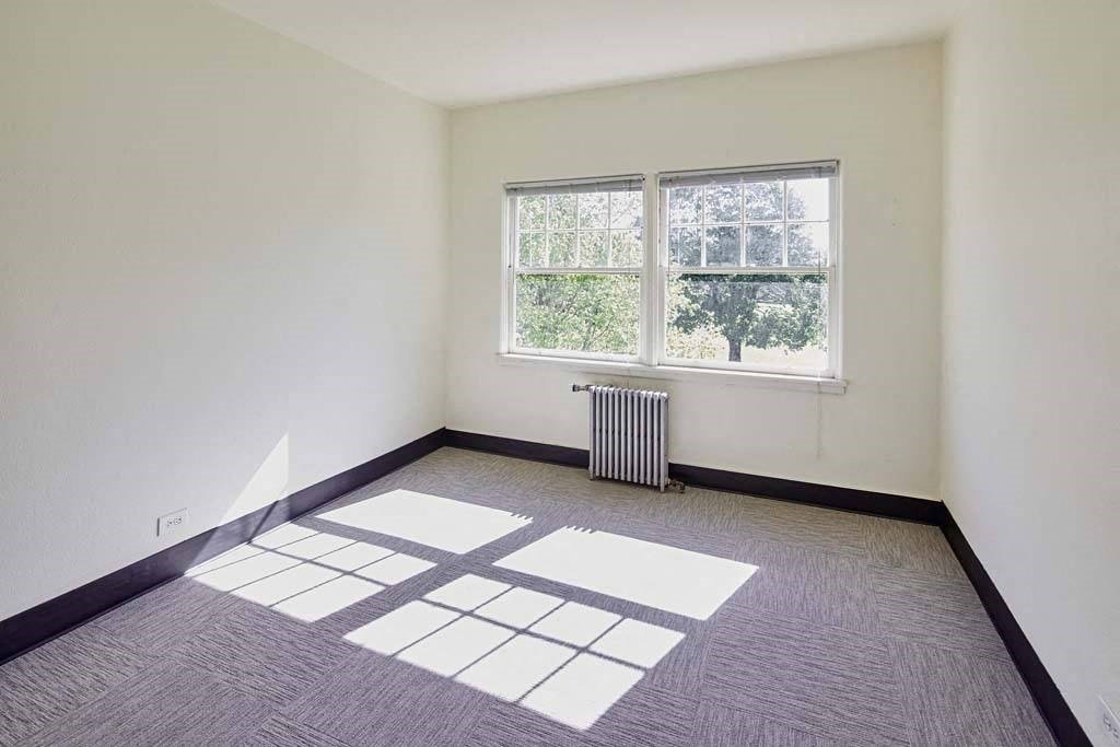empty room with a large window and a radiator at MILEPOST 5 Apartments, PORTLAND, OR