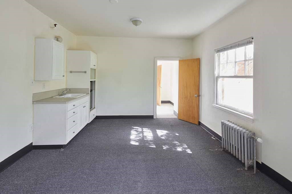 a kitchen with a stove top oven next to a window at MILEPOST 5 Apartments, PORTLAND, 97213