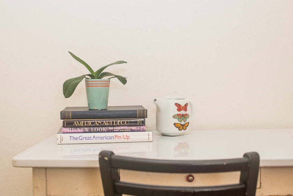 a table with a chair and a plant on top of a stack of books at MILEPOST 5 Apartments, Oregon, 97213