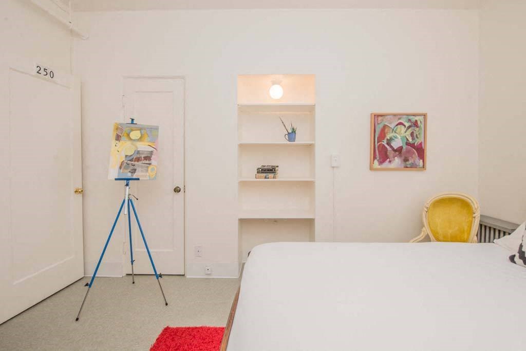 a bedroom with a bed and a painting  at MILEPOST 5 Apartments, PORTLAND Oregon