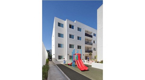 a large white building with a playground in front of it