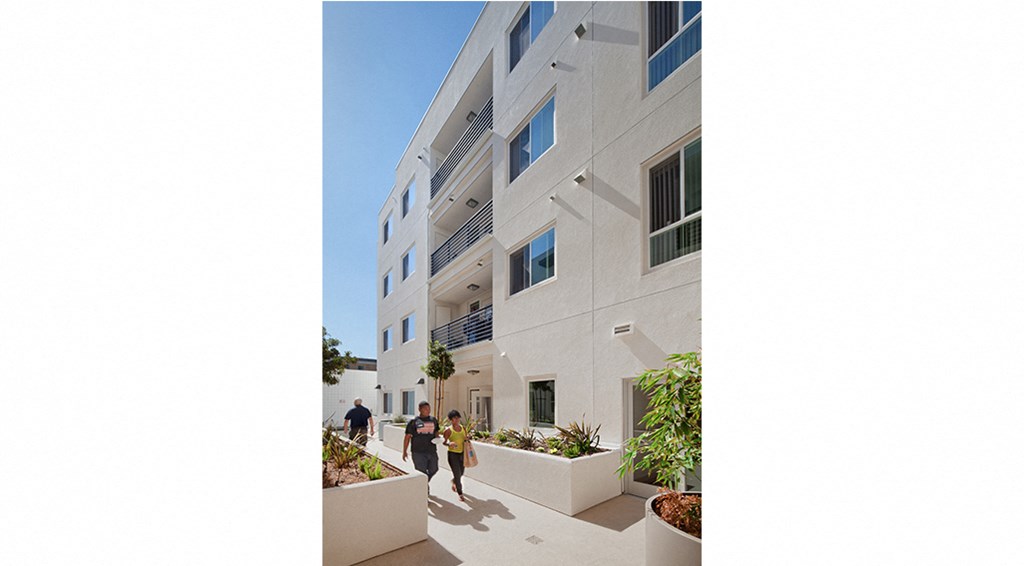 a large white building with people walking in front of it