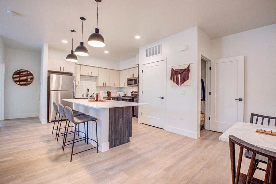 a kitchen with white cabinets and a large island with a breakfast barat 38° NORTH, Santa Rosa California