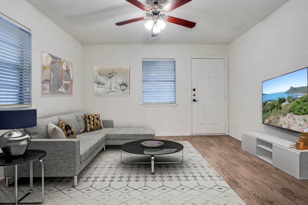 living room with a couch a table and a ceiling fan at THE EASTWOOD, Texas, 78705