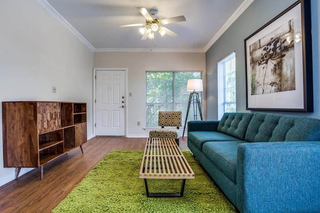 living room with a blue couch and a green rug at THE EASTWOOD, AUSTIN, 78705