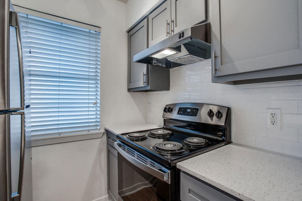kitchen with white cabinets and a black stove top oven at THE EASTWOOD, AUSTIN Texas