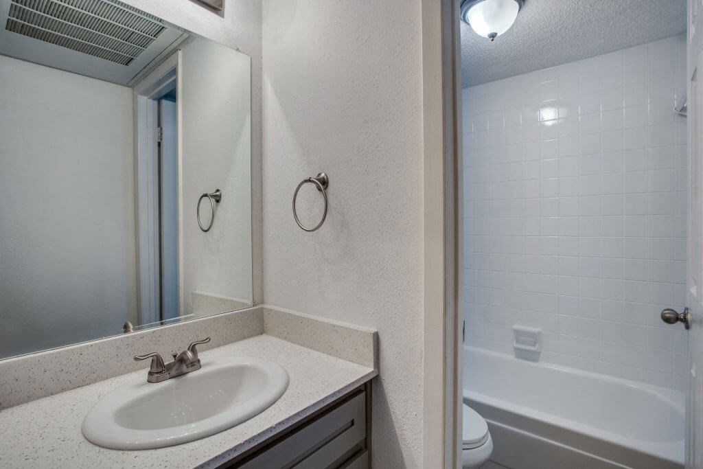 bathroom with a sink and a bathtub at THE EASTWOOD, AUSTIN