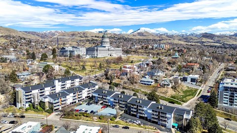 A cityscape with a large building in the center and mountains in the background.