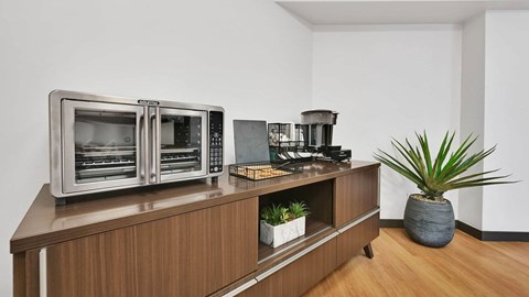 A modern kitchen with a wooden cabinet and a stainless steel oven.