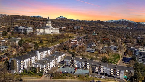 A sunset view of a city with a large white building in the center.