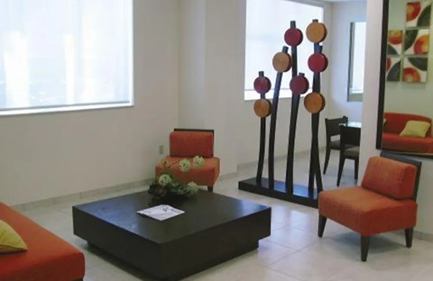 A living room with a red couch, a coffee table, and a chair.