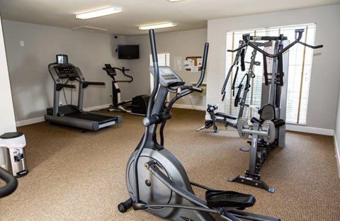 A well-equipped gym with treadmills, elliptical machines, and stationary bikes at ADDISON PLACE, CRESTVIEW, FL