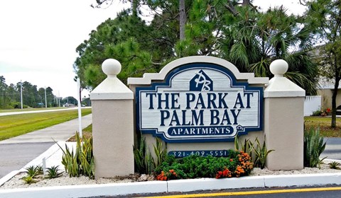 The sign for The Park at Palm Bay Apartments is blue and white.