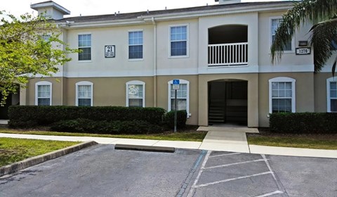 A building with a white and beige facade has a number 21 on the left side.