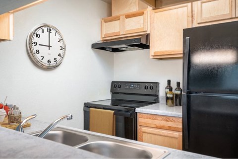 a kitchen with a black stove and a clock on the wall