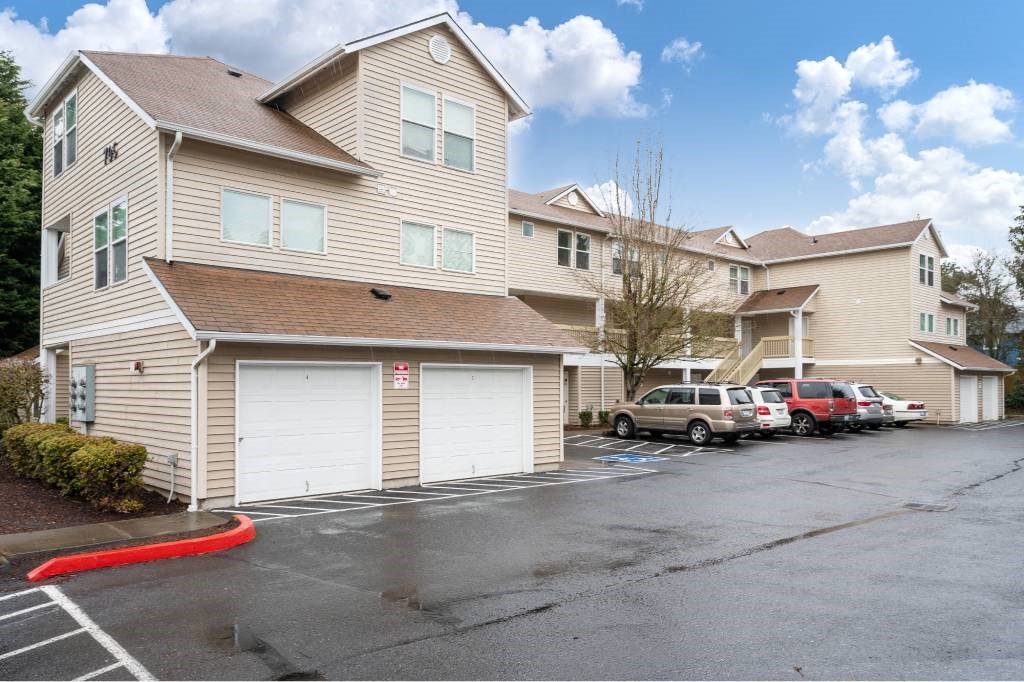a row of houses with cars parked in a parking lot at Quail Run Apartments, Vancouver