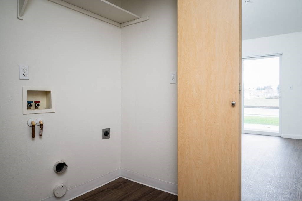 an empty room with a wooden door and a window at Quail Run Apartments, Vancouver, 98684