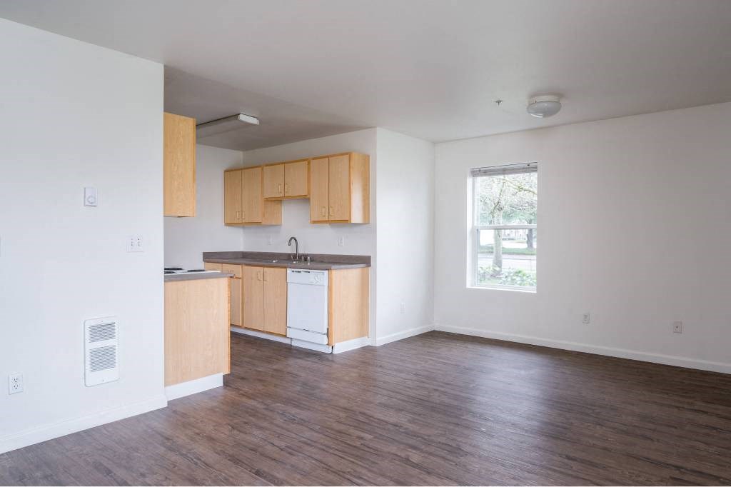 an empty living room and kitchen with wood floors at Quail Run Apartments, Vancouver, WA