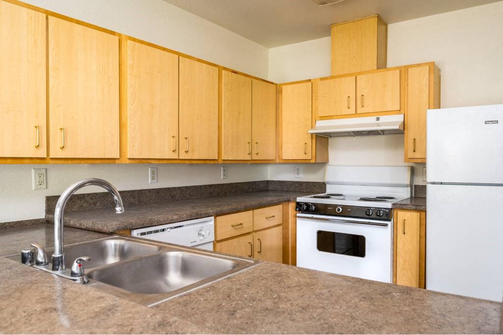 a kitchen with wooden cabinets and a sink at Quail Run Apartments, Vancouver