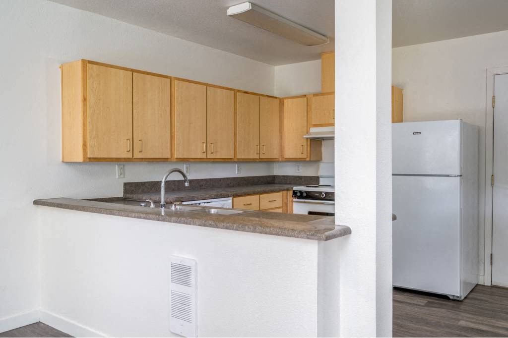 a kitchen with a counter and a refrigerator at Quail Run Apartments, WA