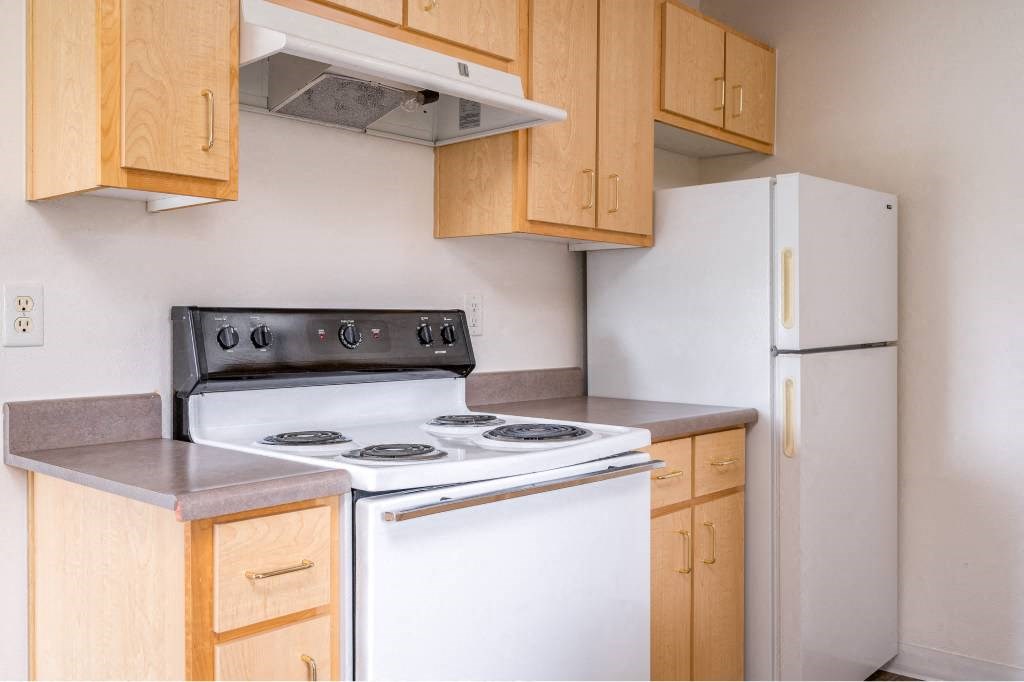 a kitchen with a stove and a refrigerator at Quail Run Apartments, Vancouver