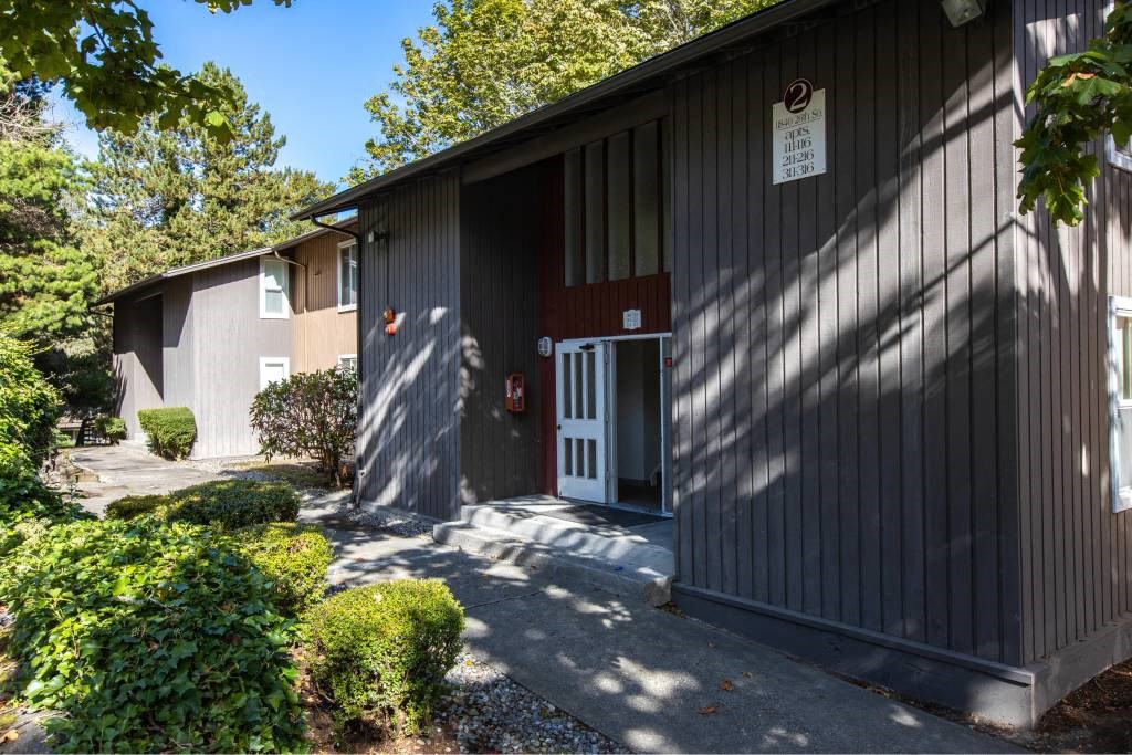 the front of a building with a driveway and a door at Whisperwood, Seattle, 98168