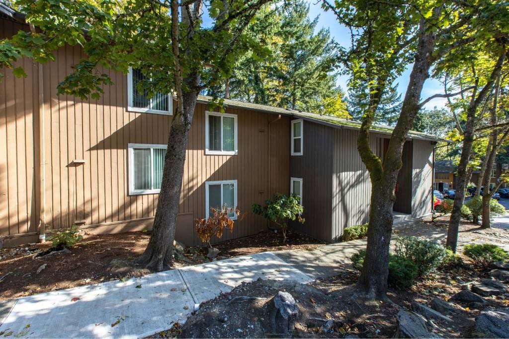 side view of a brown house with trees and a sidewalk at Whisperwood, Washington 98168