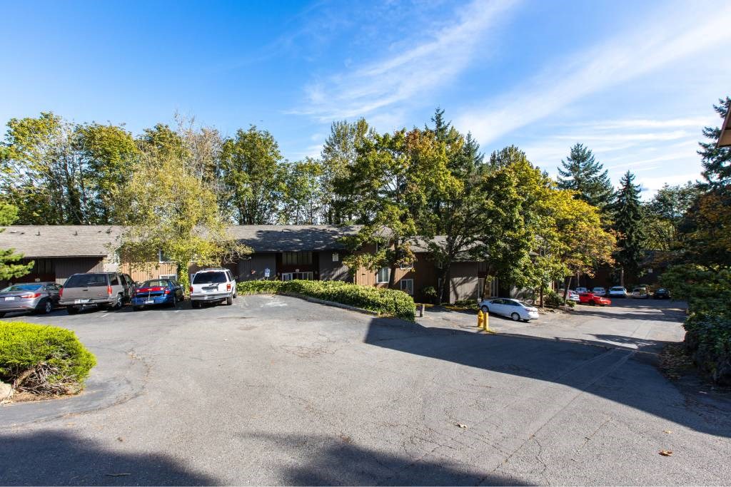 cars in a parking lot in front of an apartment in at Whisperwood, Washington 98168