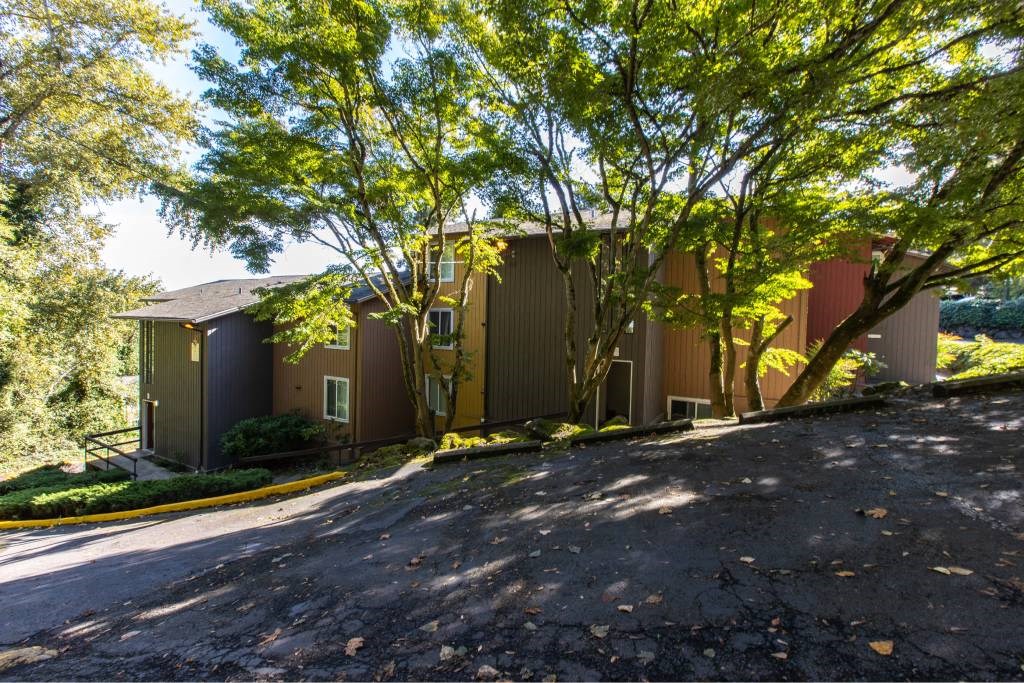 a house with a driveway and trees in front of it at Whisperwood, Seattle, WA