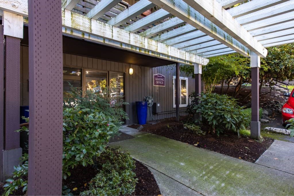 a sidewalk in front of a building with awning at Whisperwood, Seattle, 98168