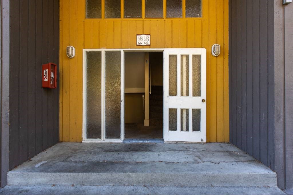 Front door of a yellow apartment at Whisperwood, Seattle, WA