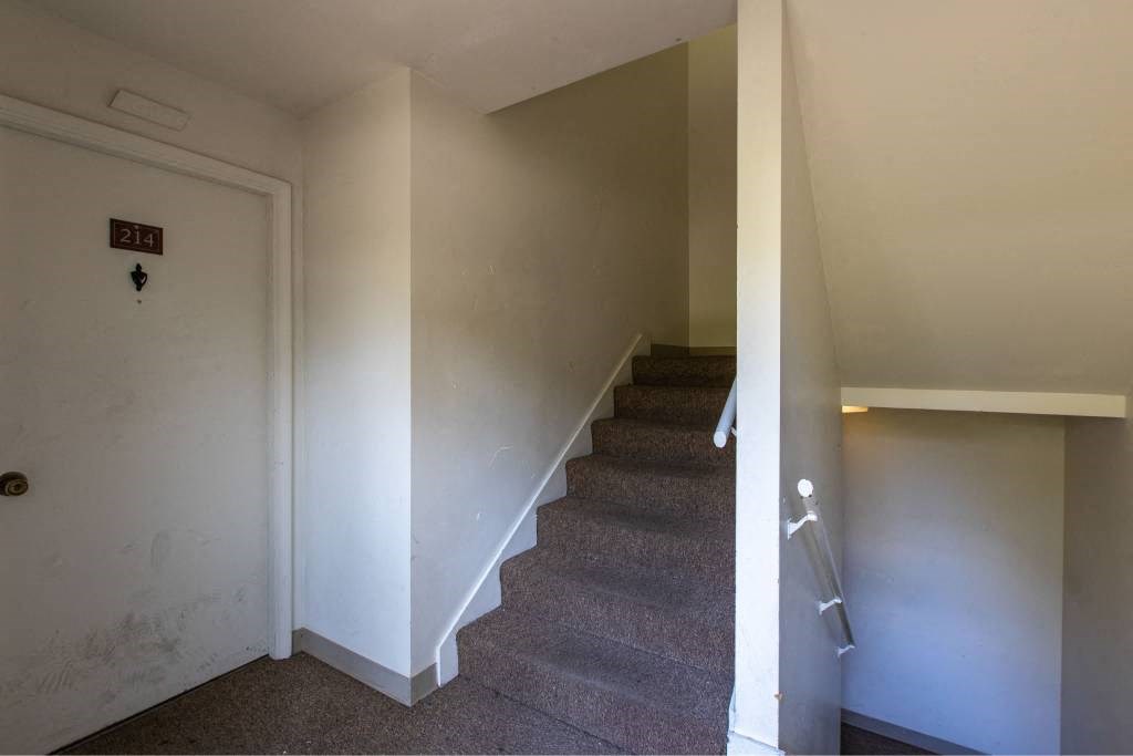 stairs in a home with white walls and carpet at Whisperwood, Seattle