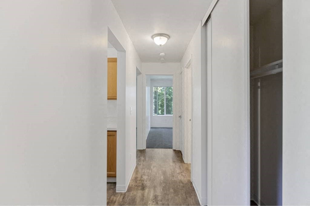 a long hallway with a door to a bedroom and a window at Whisperwood, Washington 98168