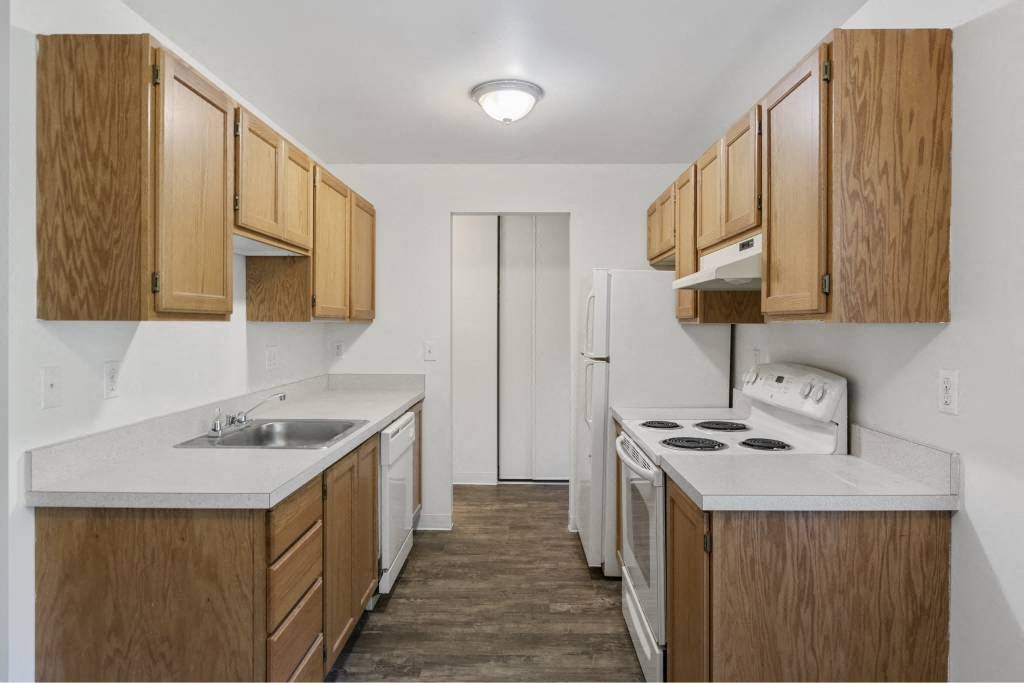 a small kitchen with white counter tops and wooden cabinets at Whisperwood, Seattle