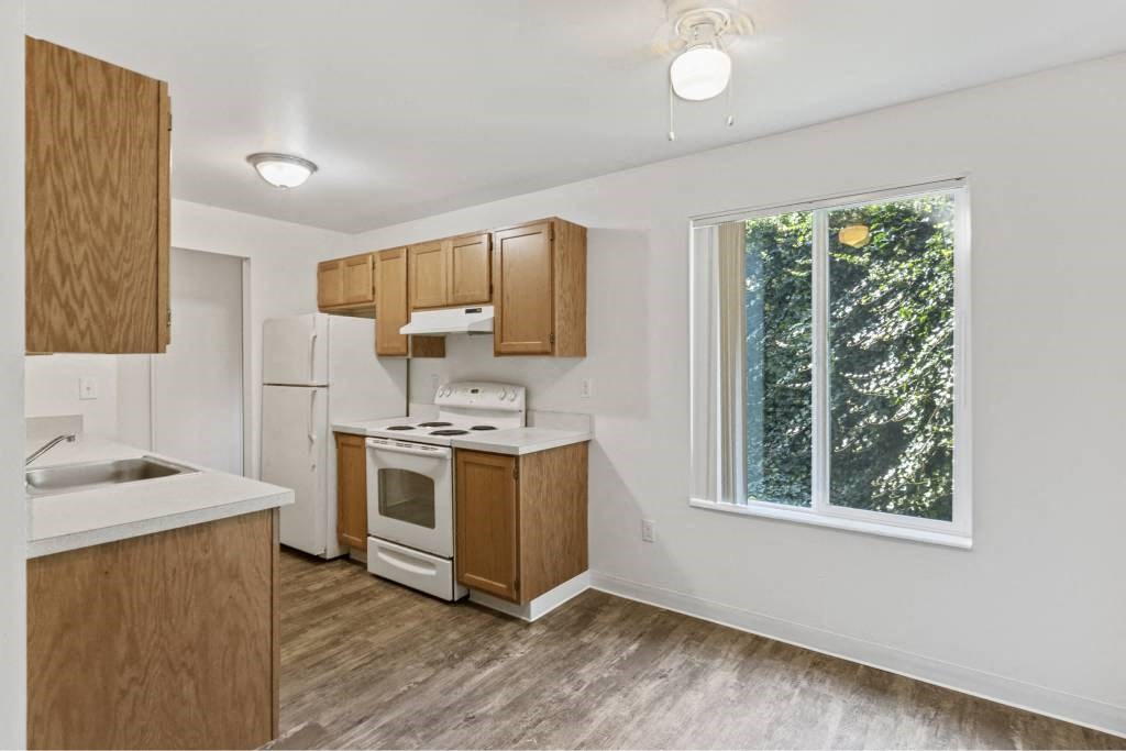 a kitchen with wooden cabinets and a window at Whisperwood, Seattle, WA 98168