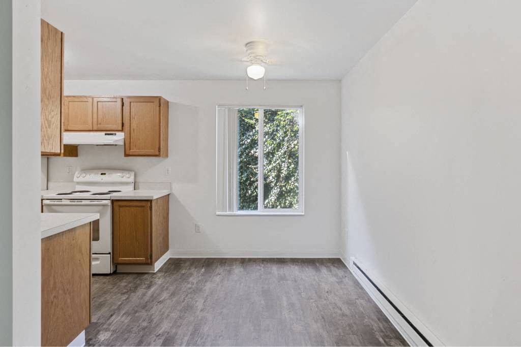 an empty kitchen with a window and wooden floors at Whisperwood, Seattle, WA 98168