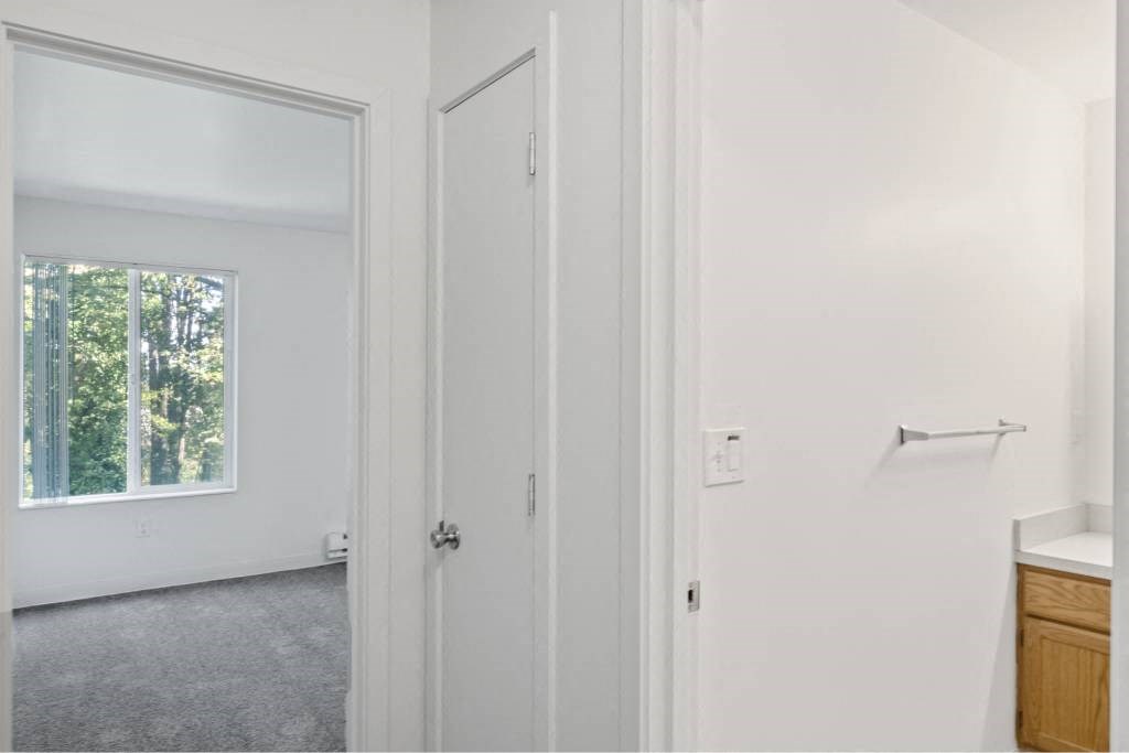 a white bathroom with a window and a door at Whisperwood, Washington