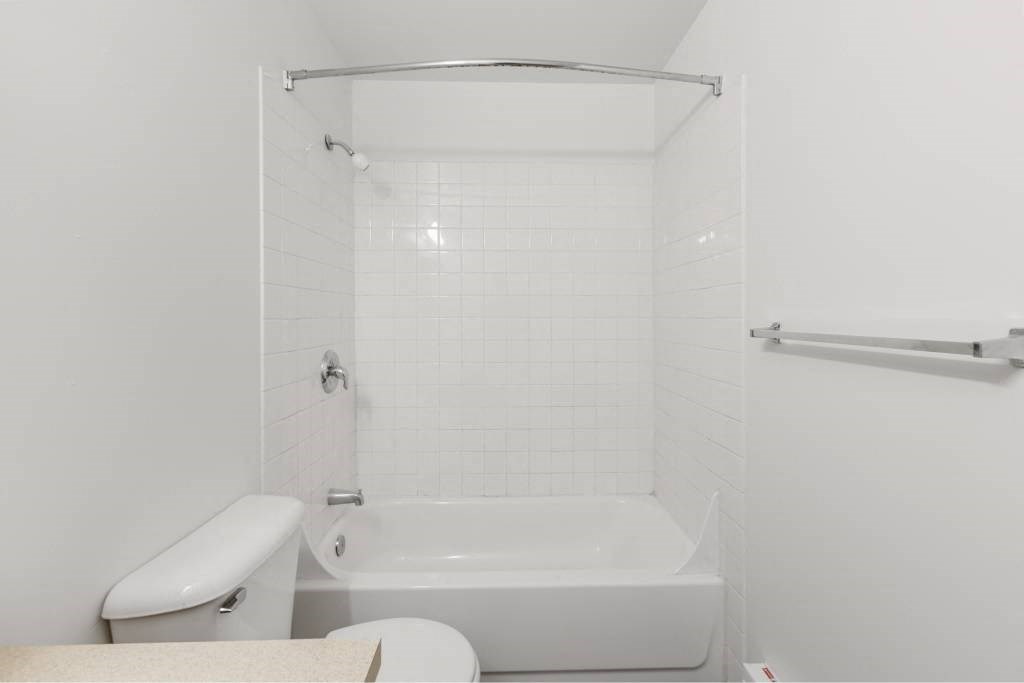 a white bathroom with a toilet and a shower at Whisperwood, Seattle, 98168