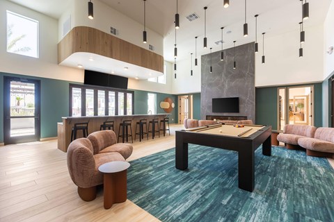 A modern living room with a pool table and a fireplace.