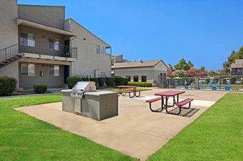 A concrete picnic table sits in a concrete courtyard at The Henley Apartments, California, 94585
