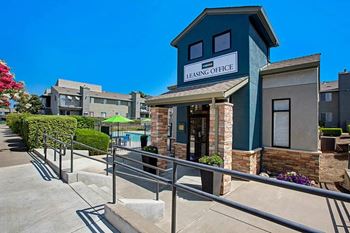 A leasing office is situated in front of a building with a pool at The Henley Apartments, Suisun City