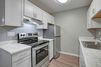 A kitchen with white cabinets and stainless steel appliances at The Henley Apartments, California, 94585
