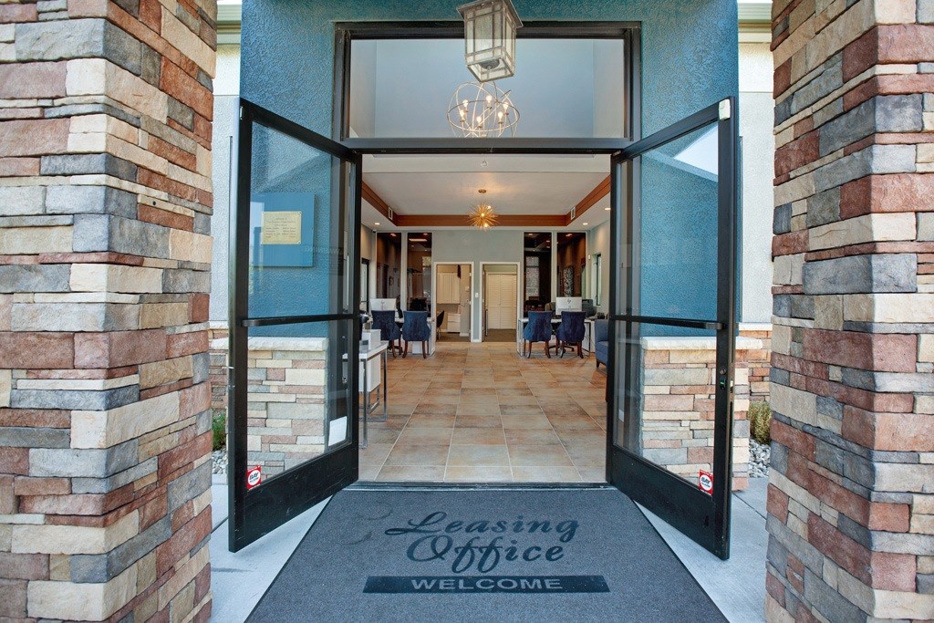 The entrance to a leasing office is shown with a mat on the floor at The Henley Apartments, Suisun City, California
