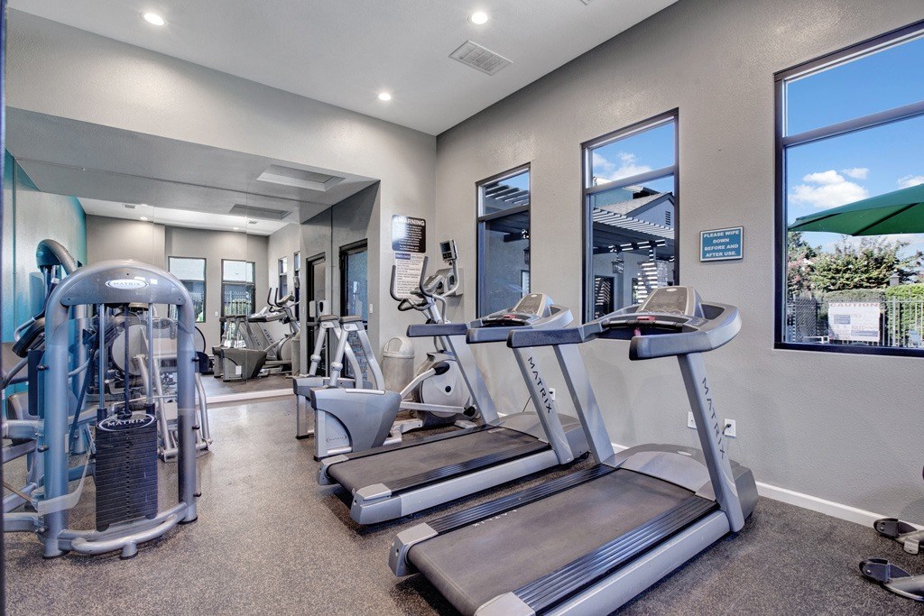 A gym with treadmills, weights, and exercise equipment at The Henley Apartments, Suisun City, CA