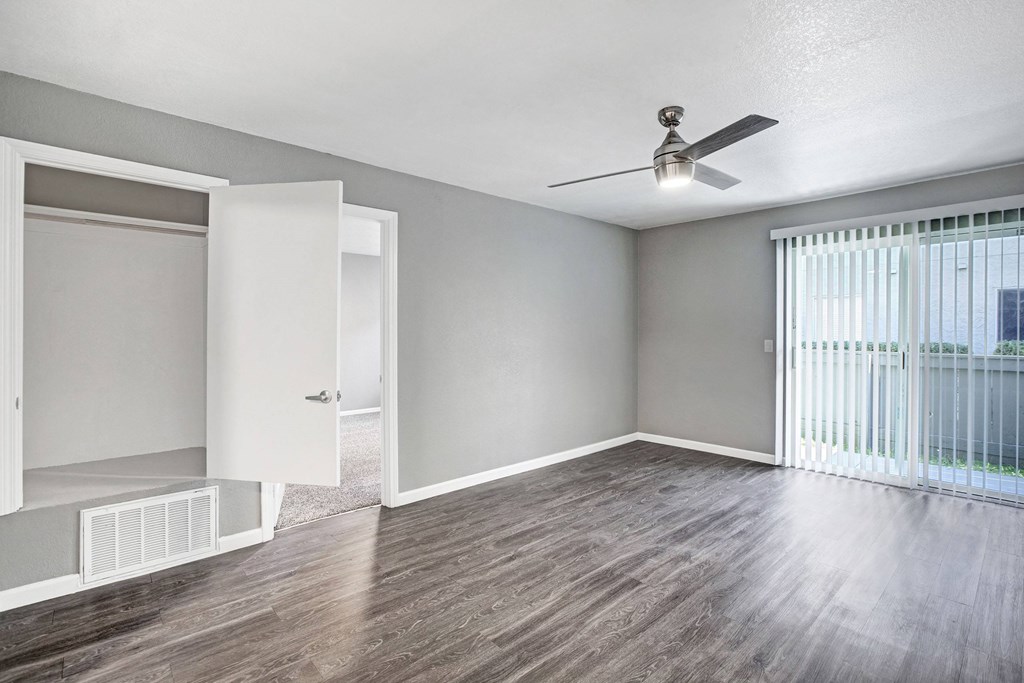 A room with a ceiling fan and a window with blinds at The Henley Apartments, California